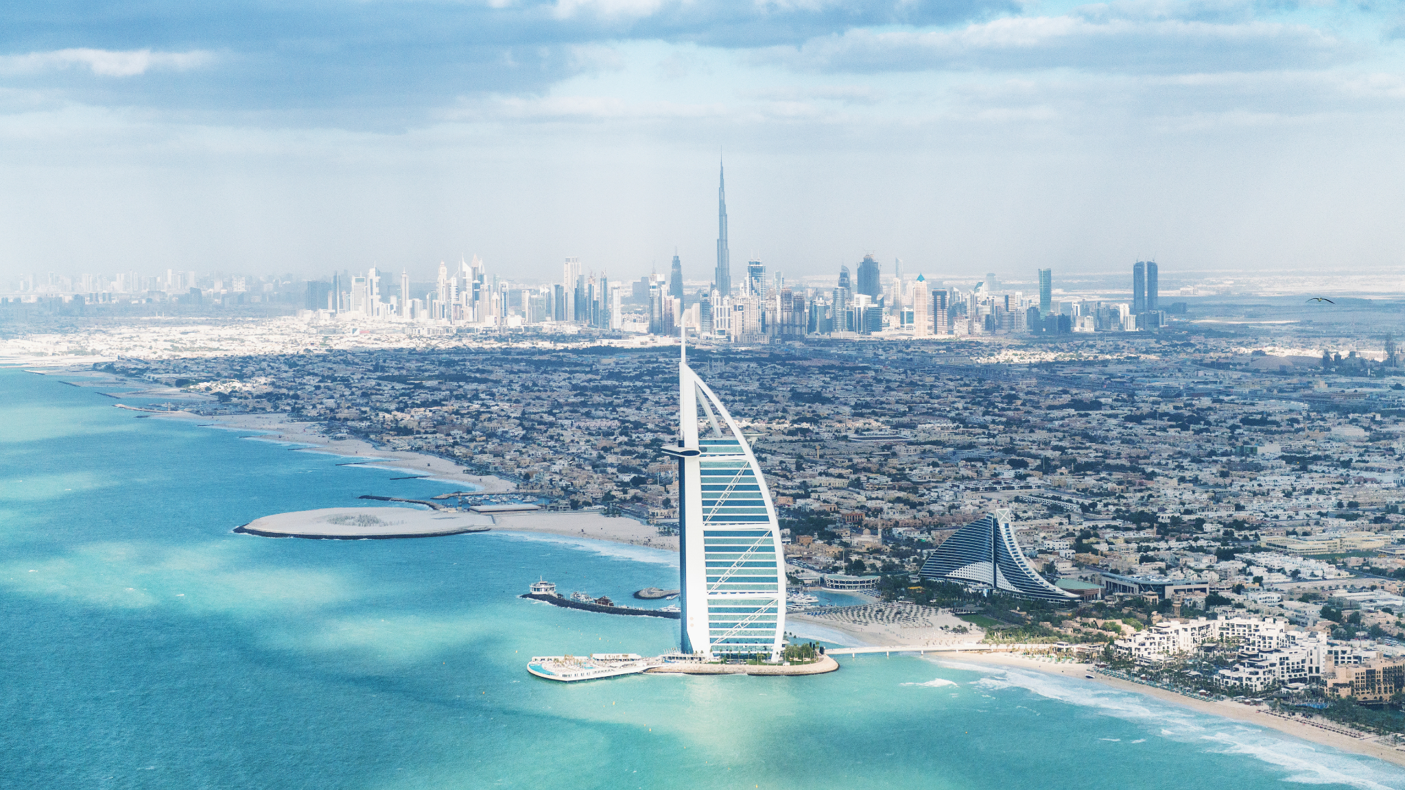 Vista aérea do Dubai com o Burj Al Arab e o skyline ao fundo